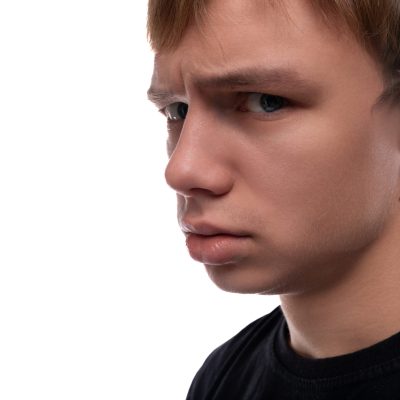 Offended young man with blond hair wearing a black T-shirt.